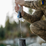 Вода проходить через фільтр Sawyer з м’якого пакета у чашку в польових умовах