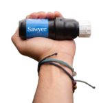 Компактний фільтр Sawyer Squeeze у руці для очищення води в походах і польових умовах