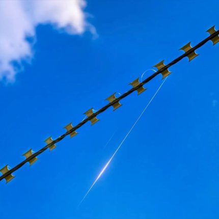 Колючий дріт комплексу Шипшина із захопленою оптоволоконною ниткою FPV-дрона на тлі неба